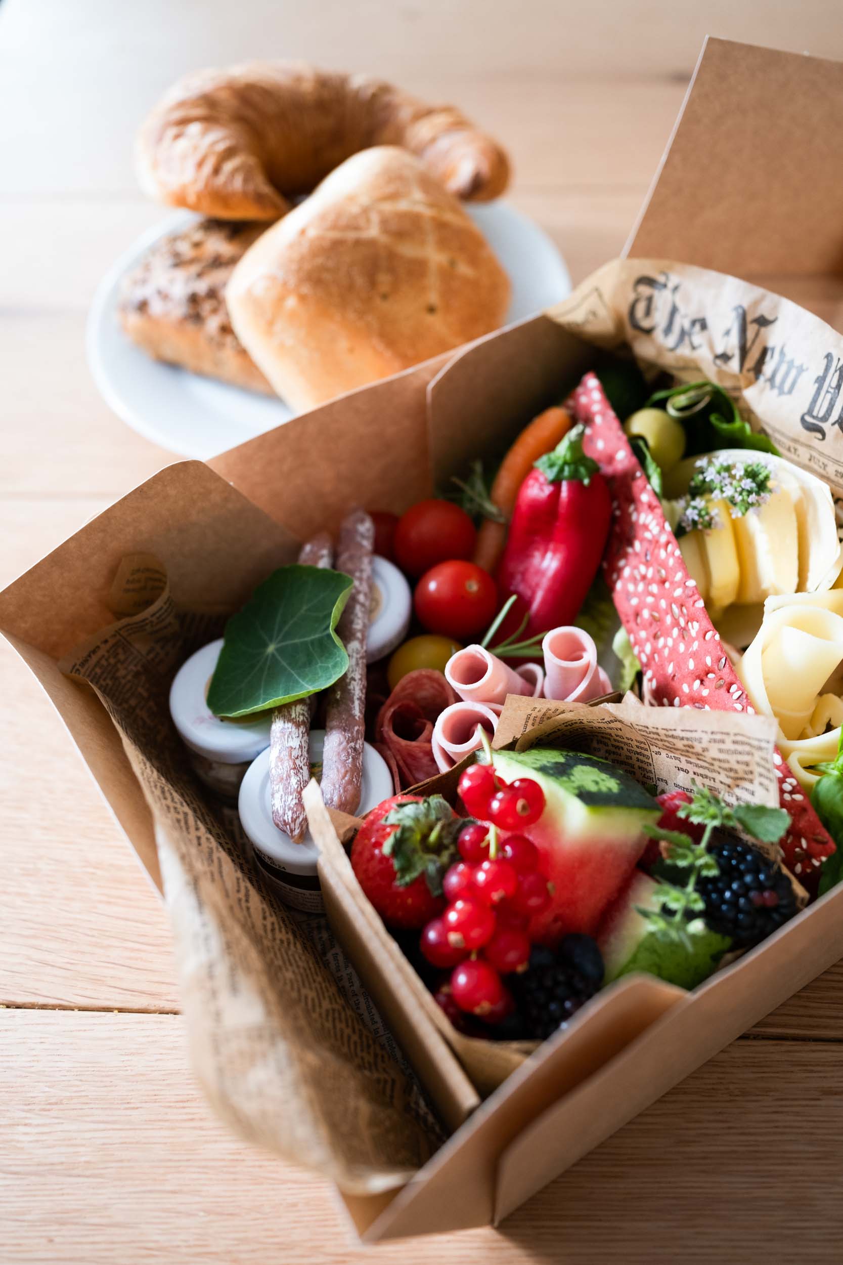Breakfast box with rolls, sausage, cheese and some fruit