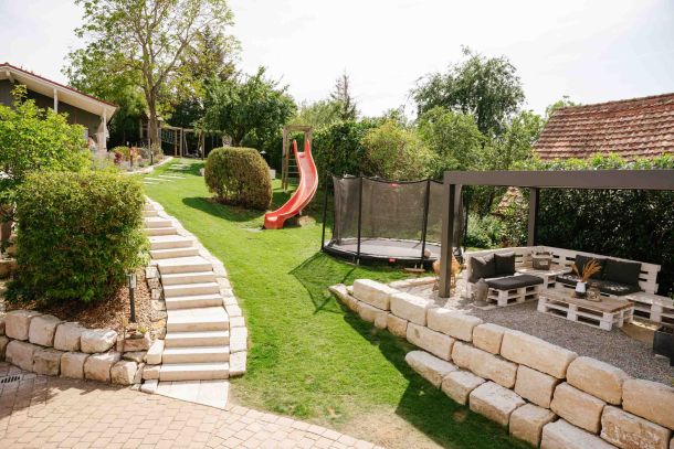 View of the spacious garden with play equipment for children and a seating area